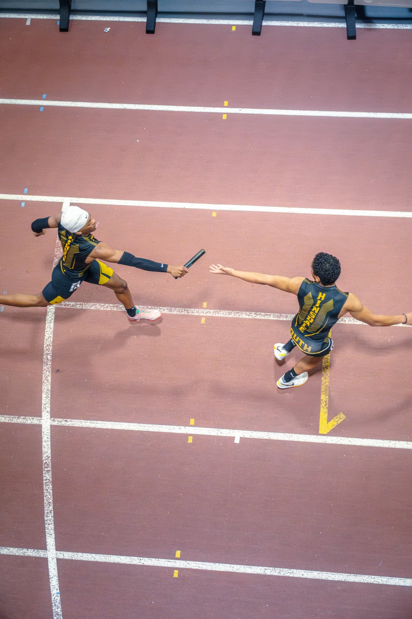 A baton handoff on the track, shot from above
