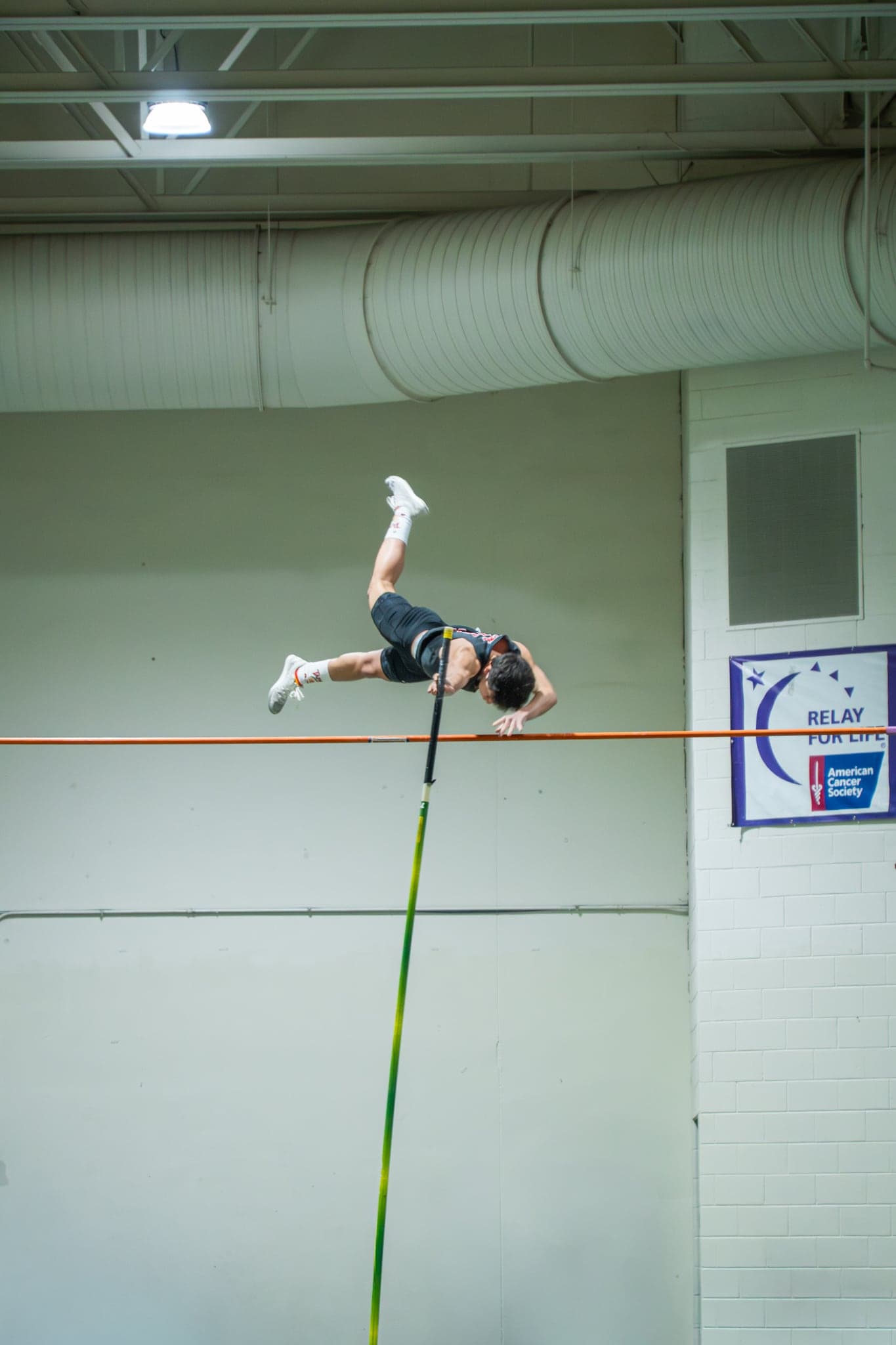 A pole vaulter clearing the bar