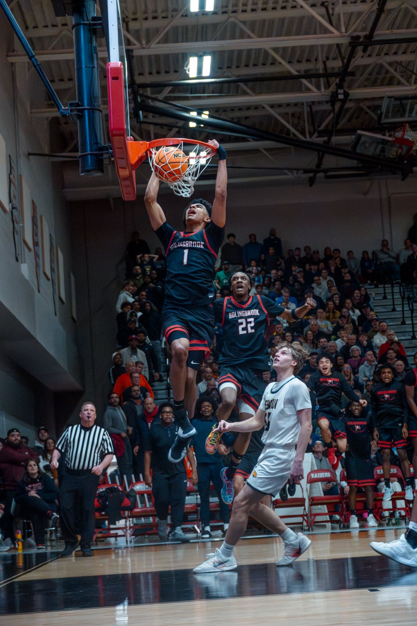 A dunk in front of a packed high-school crowd