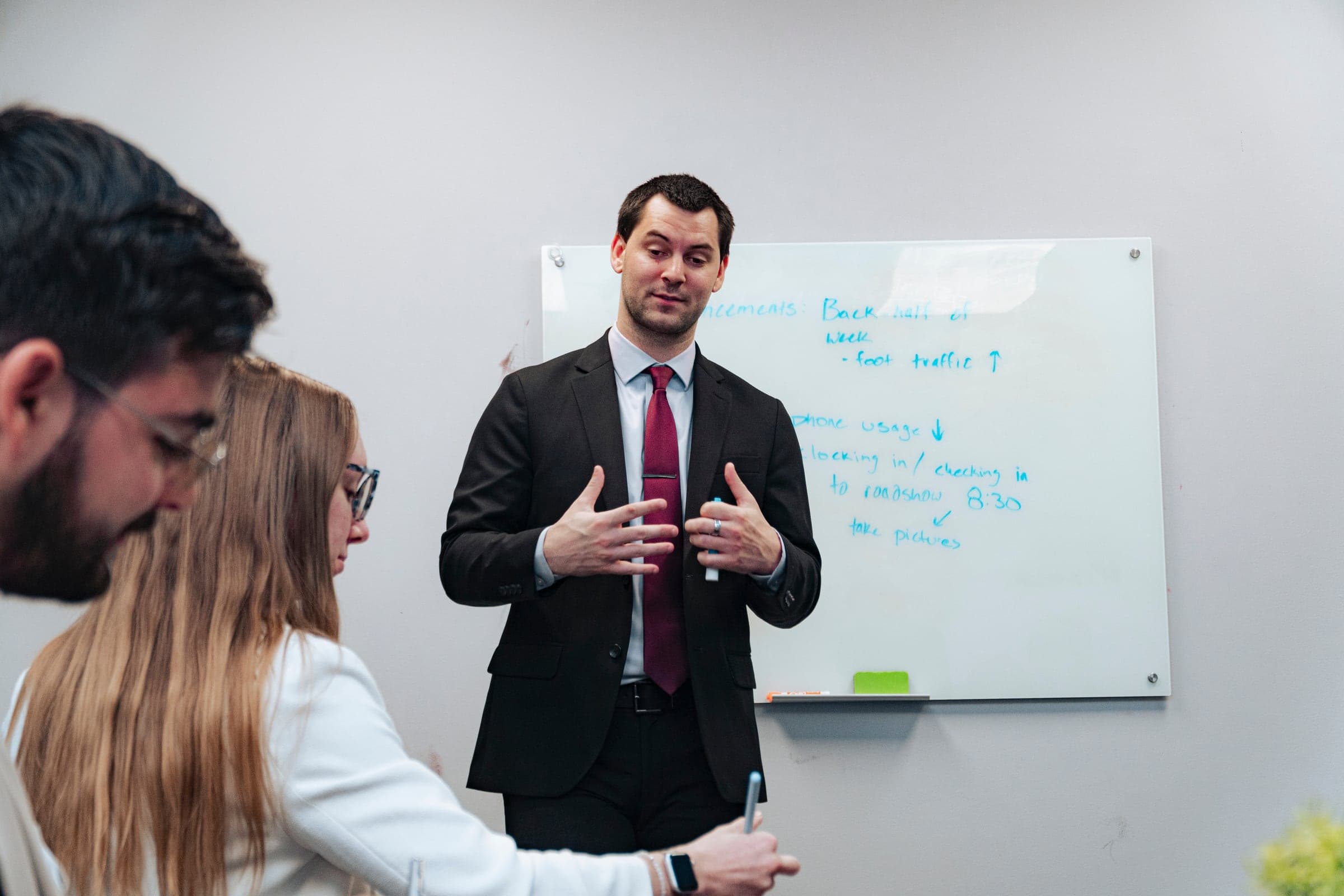 A team member presenting to colleagues at the whiteboard