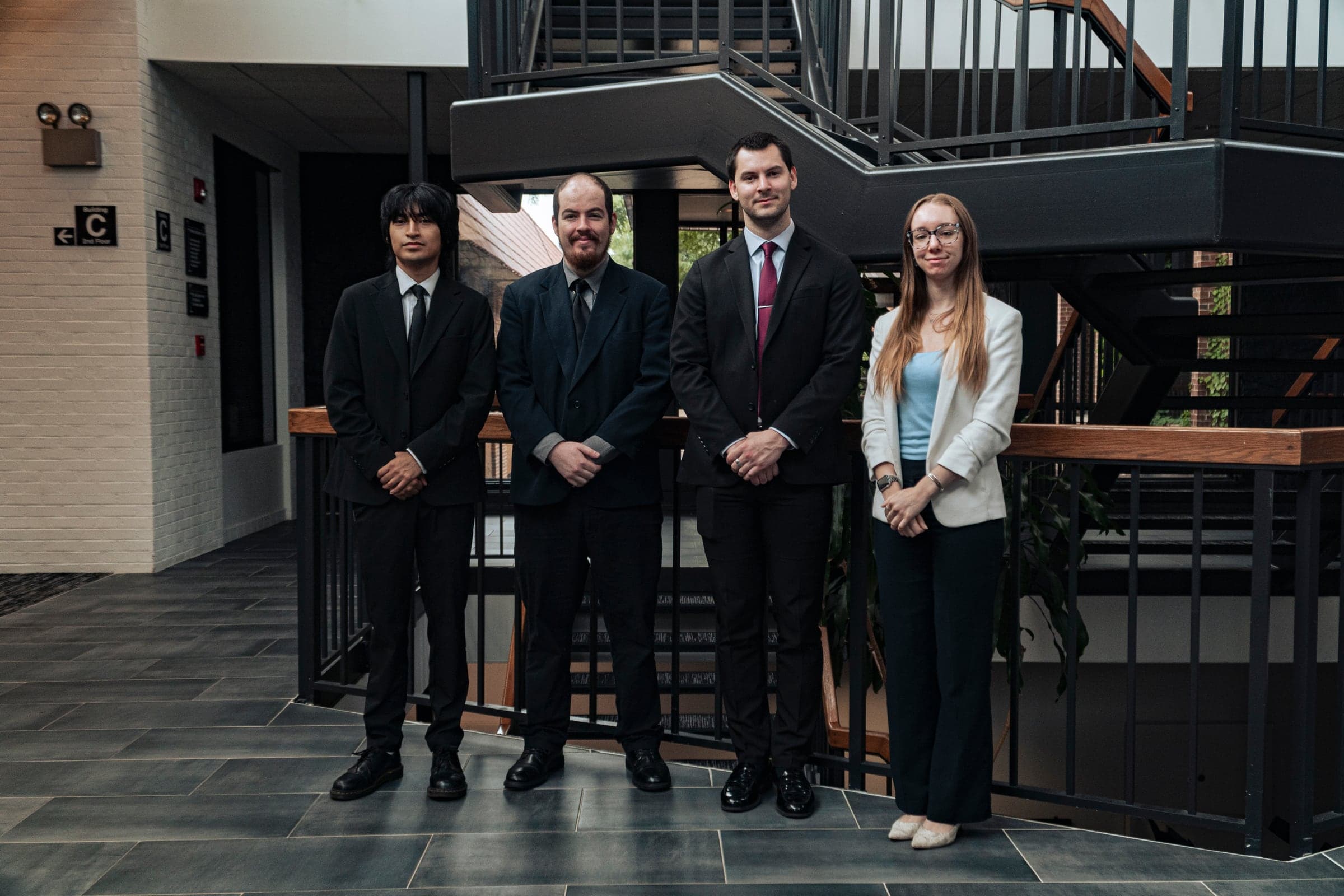 A company team photographed together on the office staircase