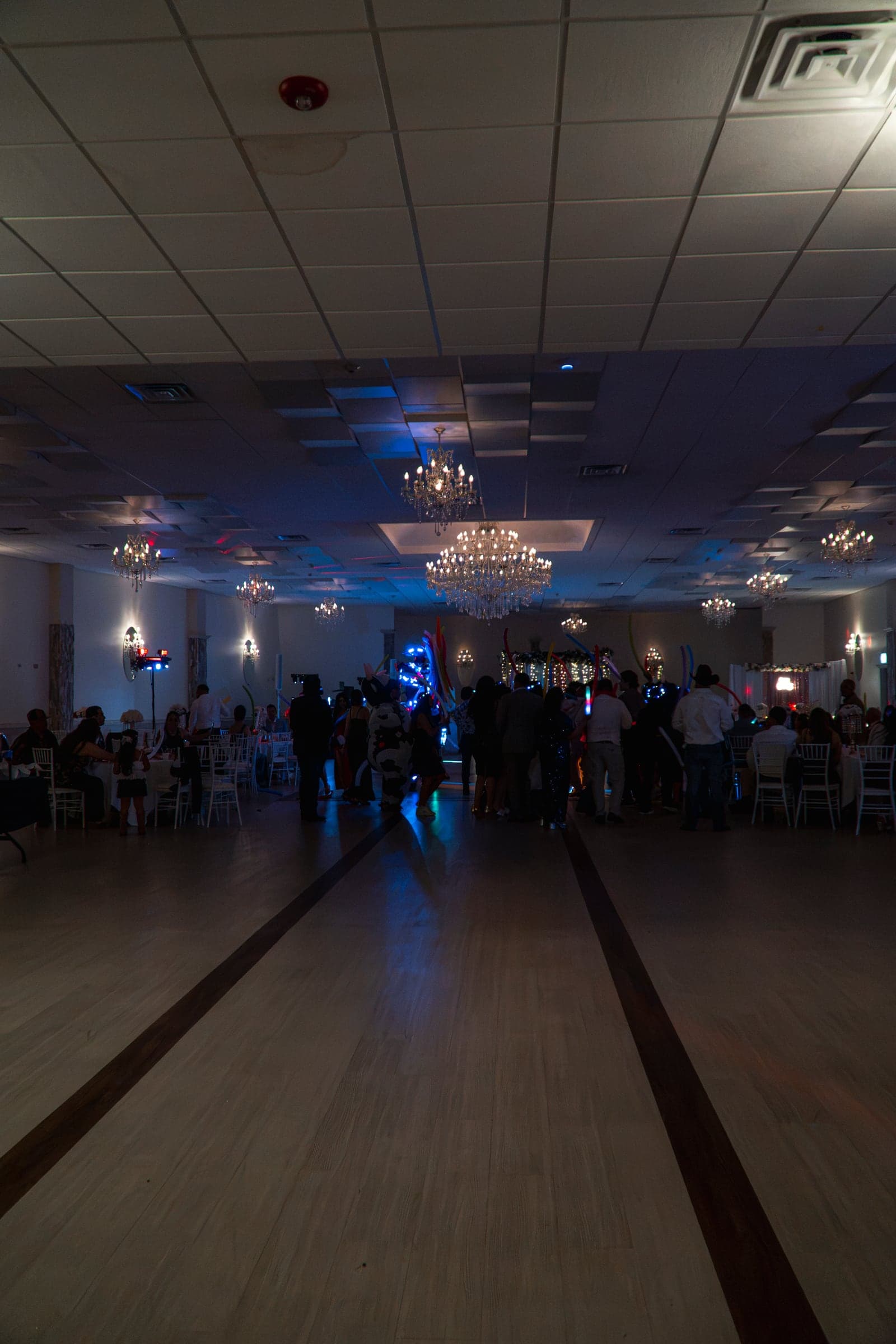 A chandelier-lit banquet hall filling up as the celebration begins