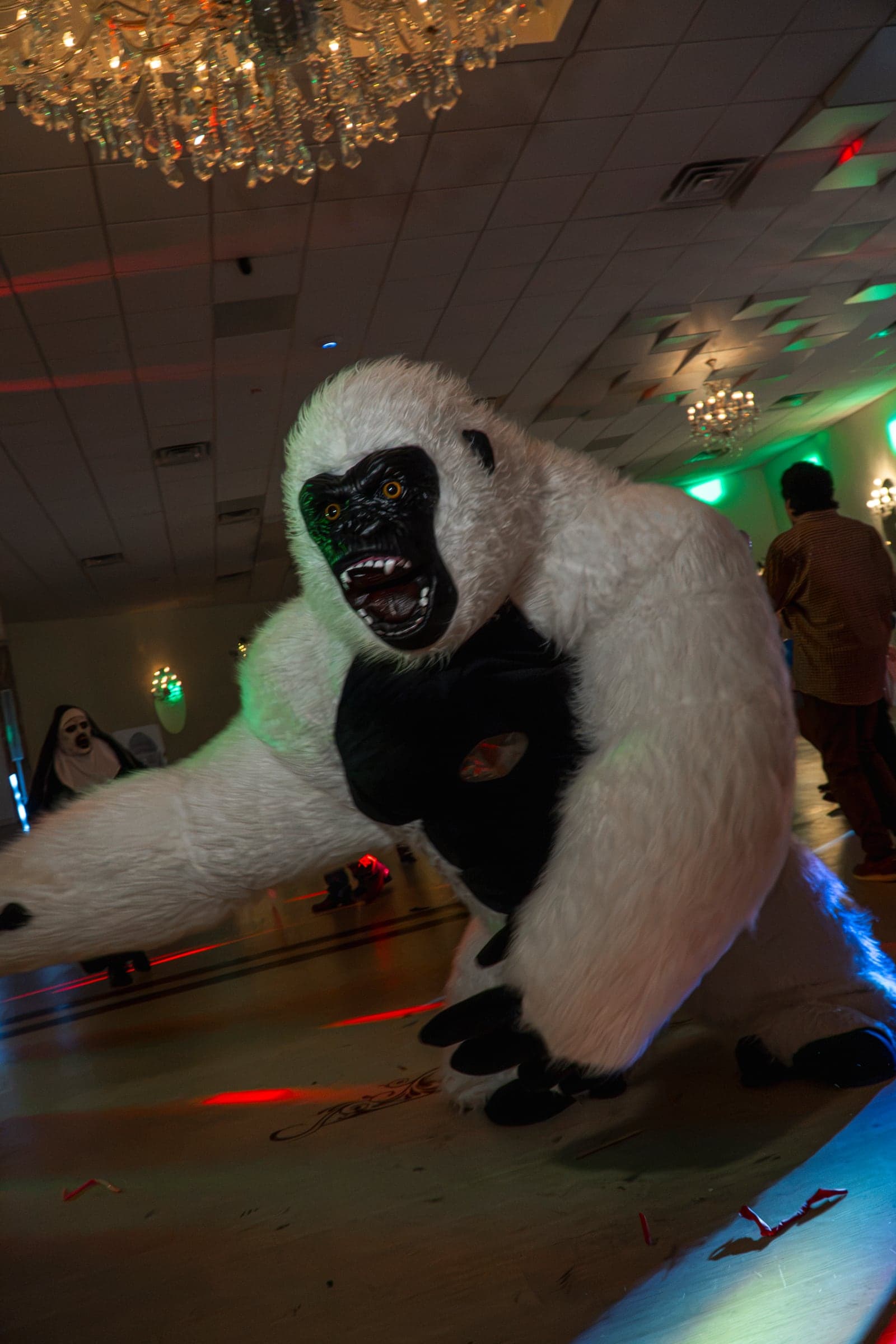 A costumed performer mid-dance as guests look on