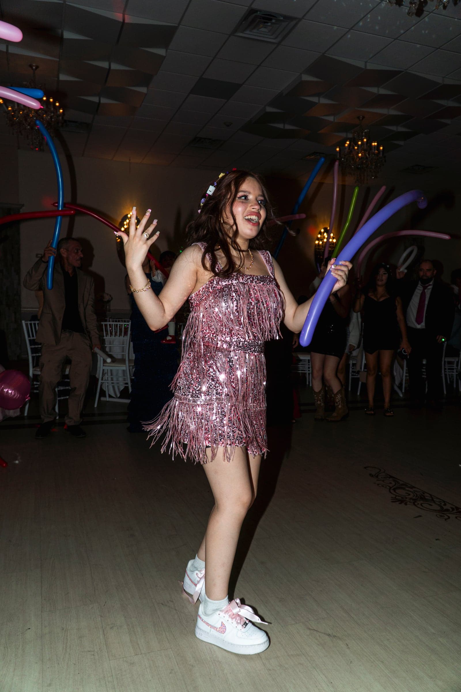 The guest of honour dancing with balloons as guests look on