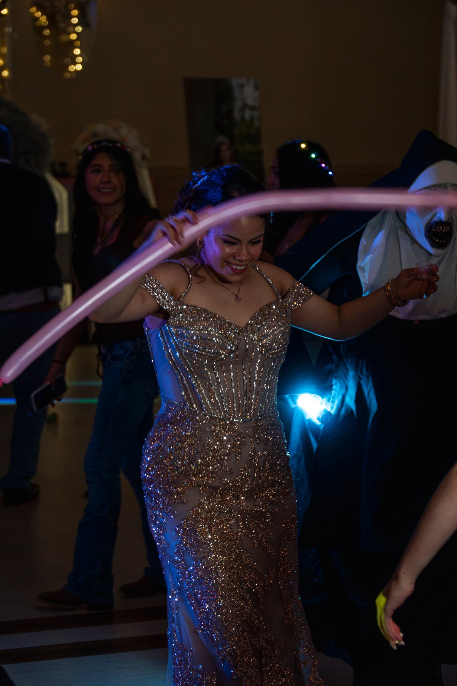 A guest dancing with a balloon under the party lights