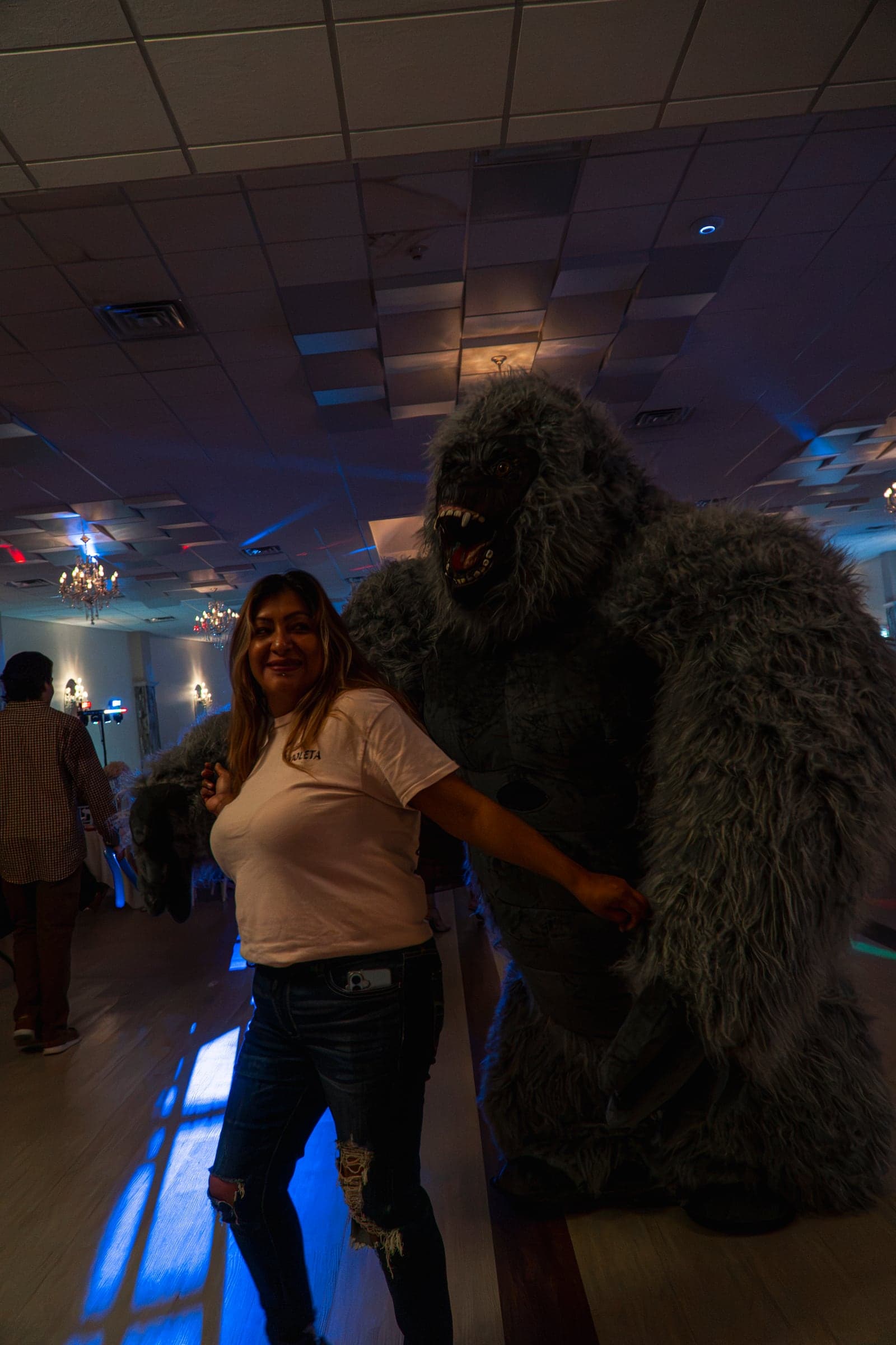 A guest posing with a costumed mascot on the dance floor