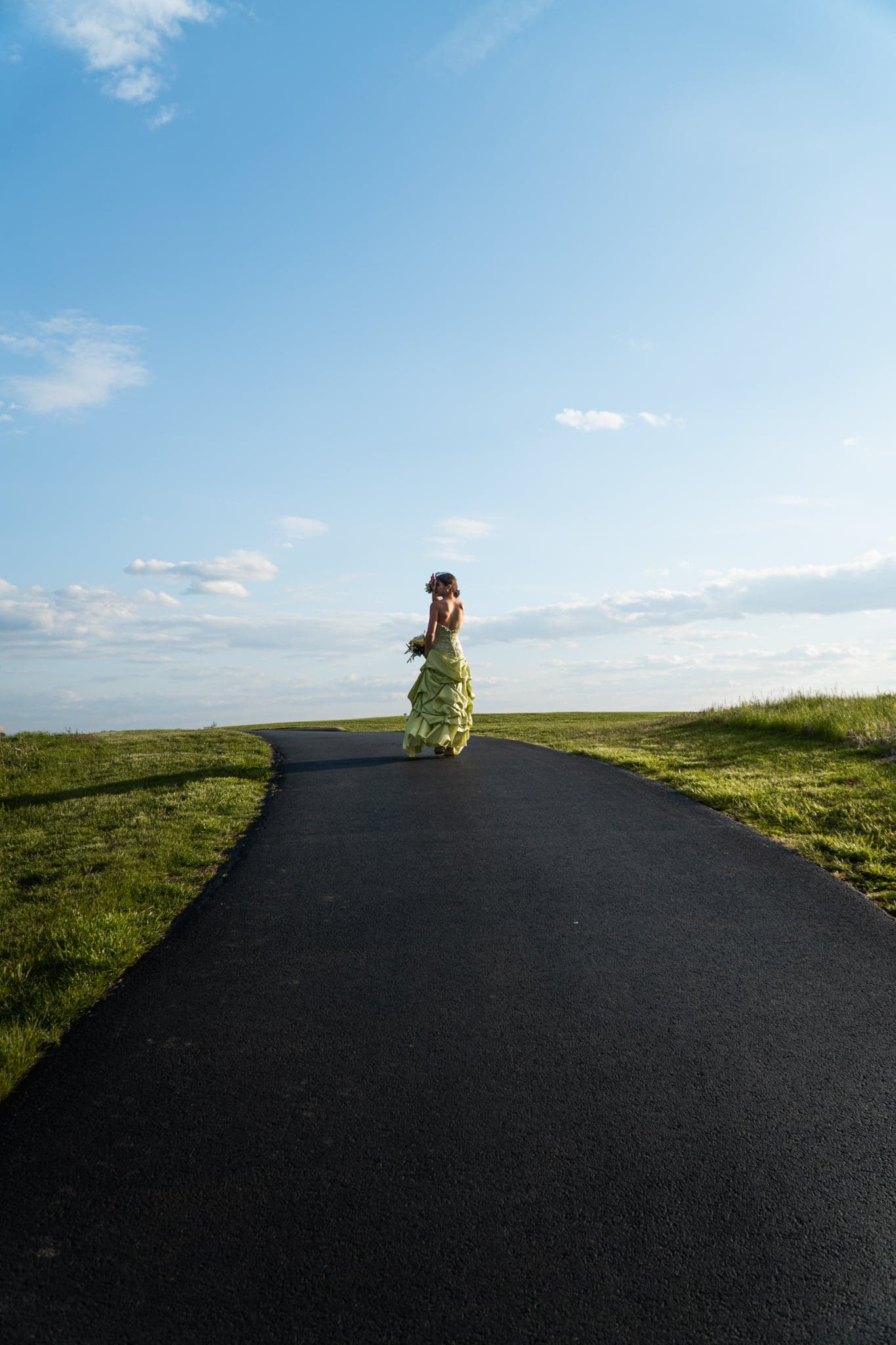 A figure walking an empty road as the light drops